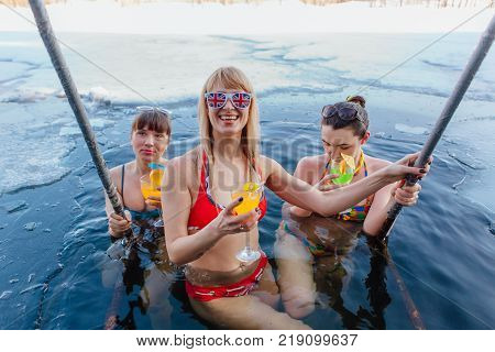 Novokuznetsk, Kemerovo region, Russia - 23 Feb, 2017 : White beaches of Siberia is an enterteiment activity where people playing beach games dressed in bikini in winter. Women in ice hole with drinks