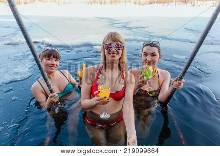 Novokuznetsk, Kemerovo region, Russia - 23 Feb, 2017 : White beaches of Siberia is an enterteiment activity where people playing beach games dressed in bikini in winter. Women in ice hole with drinks