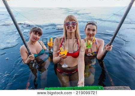Novokuznetsk, Kemerovo region, Russia - 23 Feb, 2017 : White beaches of Siberia is an enterteiment activity where people playing beach games dressed in bikini in winter. Women in ice hole with drinks