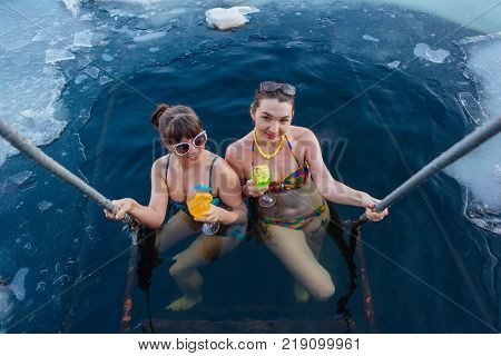 Novokuznetsk, Kemerovo region, Russia - 23 Feb, 2017 : White beaches of Siberia is an enterteiment activity where people playing beach games dressed in bikini in winter. Women in ice hole with drinks