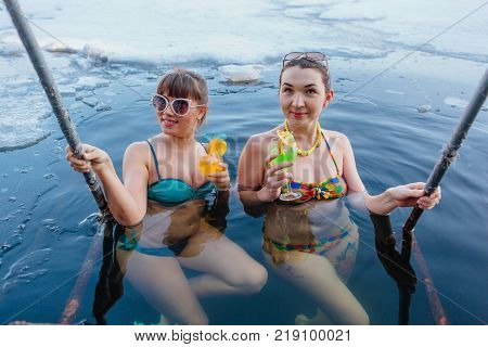 Novokuznetsk, Kemerovo region, Russia - 23 Feb, 2017 : White beaches of Siberia is an enterteiment activity where people playing beach games dressed in bikini in winter. Women in ice hole with drinks