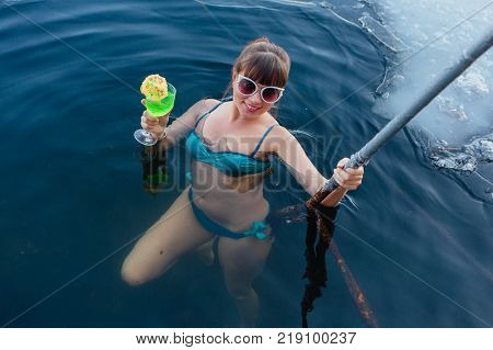 Novokuznetsk, Kemerovo region, Russia - 23 Feb, 2017 : White beaches of Siberia is an enterteiment activity where people playing beach games dressed in bikini in winter. Woman in an ice hole