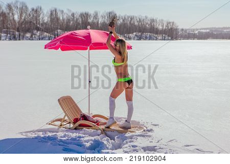 Novokuznetsk, Kemerovo region, Russia - 23 Feb, 2017 : White beaches of Siberia is an enterteiment activity where people playing beach games dressed in bikini in winter. Woman in bikini with pineapple