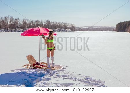 Novokuznetsk, Kemerovo region, Russia - 23 Feb, 2017 : White beaches of Siberia is an enterteiment activity where people playing beach games dressed in bikini in winter. Woman in bikini with pineapple