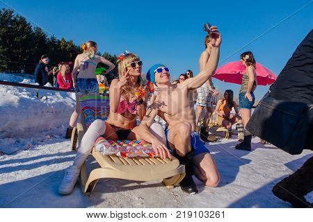 Novokuznetsk, Kemerovo region, Russia - 23 Feb, 2017 : White beaches of Siberia is an enterteiment activity where people playing beach games dressed in bikini in winter. Woman in bikini and a man
