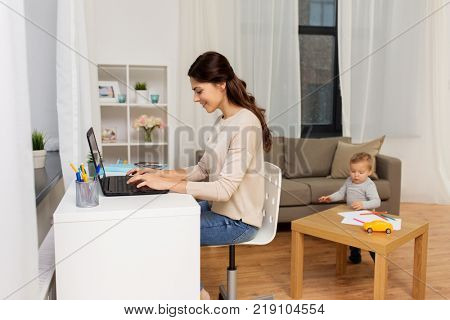 motherhood, multi-tasking, family and technology concept - happy mother with baby and laptop working at home