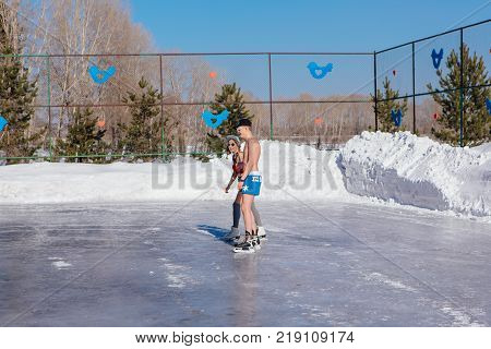 Novokuznetsk, Kemerovo region, Russia - 23 Feb, 2017 : White beaches of Siberia is an enterteiment activity where people playing beach games dressed in bikini in winter. Couple in shorts on ice skates