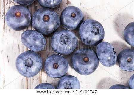 Fruits of northern highbush blueberry (Vaccinium corymbosum) on a wooden board close up