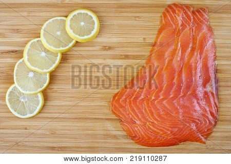 Smoked Fillet trout with lemon on a cutting board. Seafood.