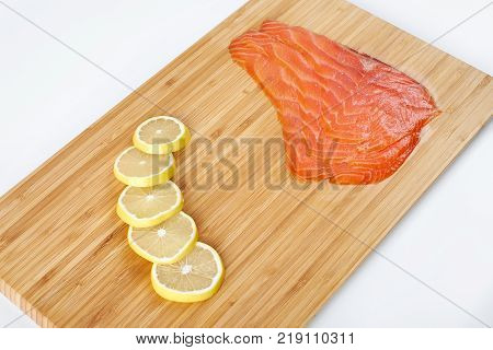 Smoked Fillet salmon with lemon on a board. Seafood.