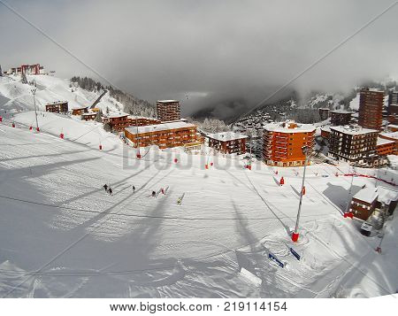 Ski slope, lift and houses of winter resort, Paradiski, France, French Alps