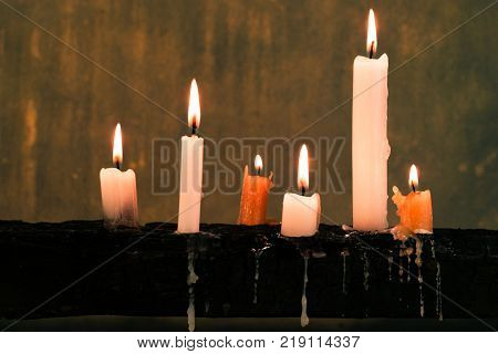 Candles on an old wooden burnt table. Beautiful dark background. Religious concept.