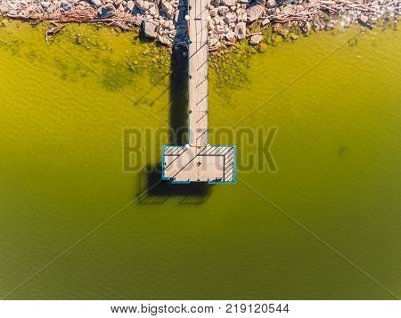 Aerial view of ocean beach. Sand beach and pier view from above. Beach aerial view of ocean water and sand shore. Aerial shot of beach