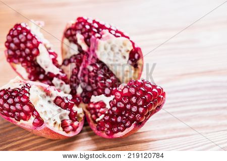 Big red pomegranate on the wooden board. Ripe granet fruit. Broken pomegranate.