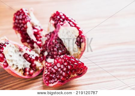 Big red pomegranate on the wooden board. Ripe granet fruit. Broken pomegranate.