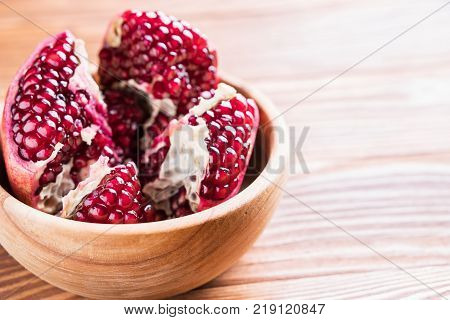 Big red pomegranate on the wooden board. Ripe granet fruit. Broken pomegranate.