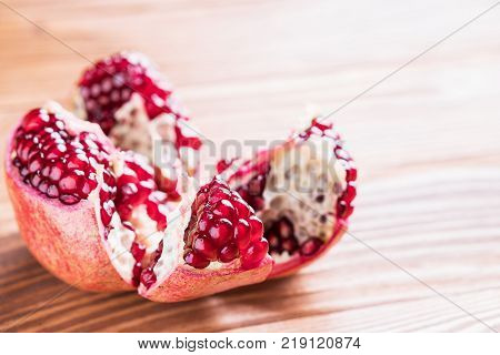 Big red pomegranate on the wooden board. Ripe granet fruit. Broken pomegranate.