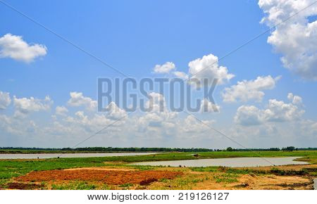 Countryside landscape with pondscanals. Summer nature with water. Blue sky with clouds.