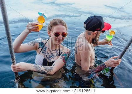 Novokuznetsk, Kemerovo region, Russia - 23 Feb, 2017 : White beaches of Siberia is an enterteiment activity where people playing beach games dressed in bikini in winter. Couple in ice hole