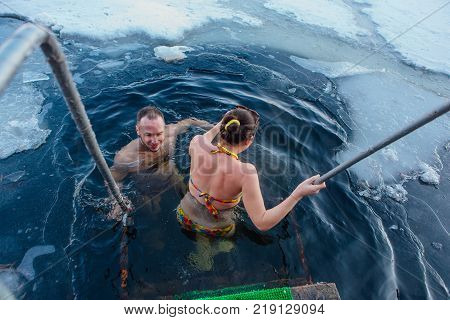 Novokuznetsk, Kemerovo region, Russia - 23 Feb, 2017 : White beaches of Siberia is an enterteiment activity where people playing beach games dressed in bikini in winter. Couple in ice hole