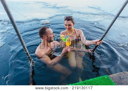 Novokuznetsk, Kemerovo region, Russia - 23 Feb, 2017 : White beaches of Siberia is an enterteiment activity where people playing beach games dressed in bikini in winter. Couple in ice hole