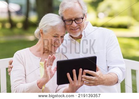 old age, technology and people concept - happy senior couple with tablet pc computer having video chat at summer park