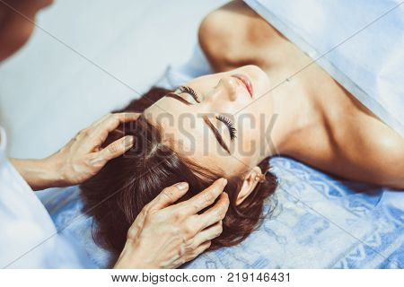 Spa. Brunette woman enjoying the anti-aging facial massage