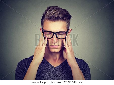 Closeup portrait of a sad young man with worried stressed face expression looking down