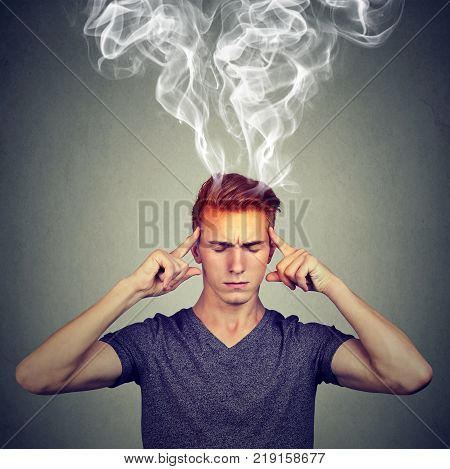 man thinks very intensely having headache isolated on gray wall background