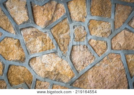 Masonry wall of colors stones with irregular pattern texture background
