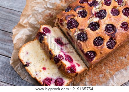 Sweet cherry cake on a wooden background. Homemade dessert.