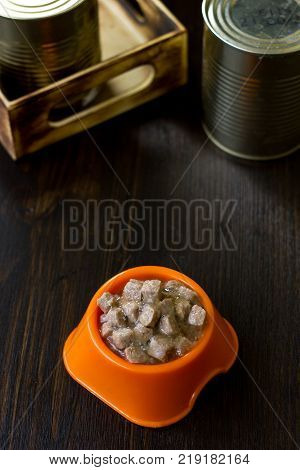 Canned pet food in a orange plastic bowl