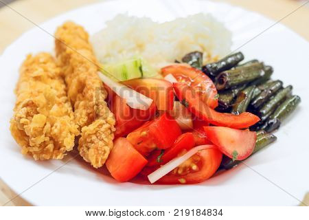 Plate with food. Rice tamates meat and beans. Afternoon dinner.