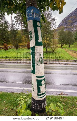 EIDFJORD, NORWAY - 21 SEPTEMBER 2017: Knitted woolen coverings on tree trunks in Eidfjord in Norway