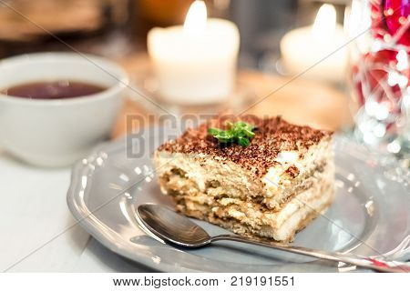 Tiramisu, traditional Italian dessert on a white plate