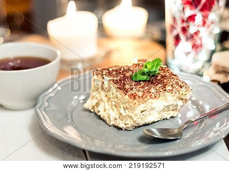 Tiramisu, traditional Italian dessert on a white plate
