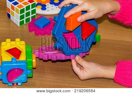 Closeup Of Child's Hand Taking Bright Mosaic Parts. Learning Colors At Home. Toddler Boy In A Stripe