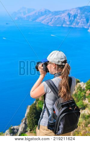 Woman taking photos of beautiful scenery at Path of Gods in Tyrrhenian sea Amalfi coast Italy