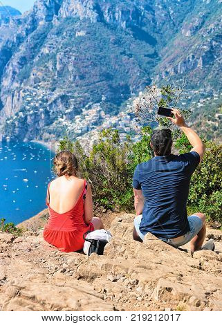 Man taking photos of beautiful scenery at Path of Gods in Tyrrhenian sea Amalfi coast Italy
