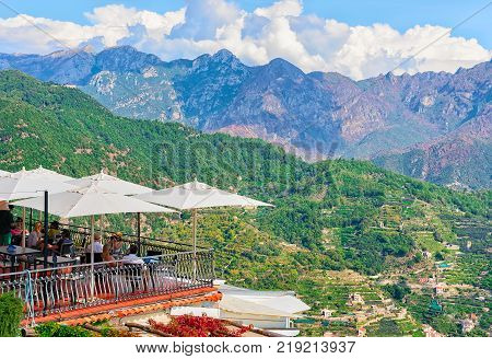 Ravello Italy - October 2 2017: Open air street restaurant with umbrellas Ravello village Tyrrhenian sea Amalfi coast Italy
