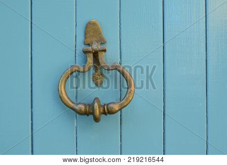 Blue handle door rusty iron ring in wood doorway
