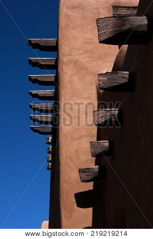 Vigas beams protrude from the adobe walls of a building in Santa Fe, New Mexico,