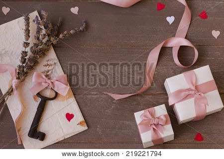 Frame of gifts, key, letter and hearts on a wooden background. Valentine's day.