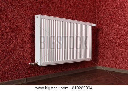 white heating radiator under in red room