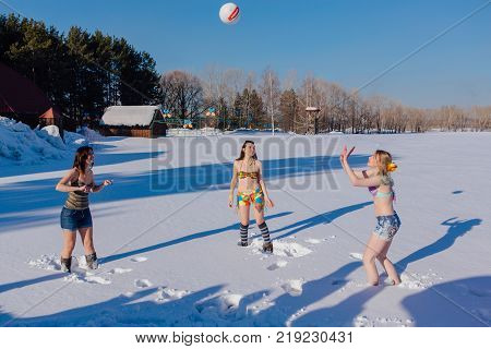 Novokuznetsk, Kemerovo region, Russia-23 Feb, 2017: White beaches of Siberia is an enterteiment activity where people playing beach games dressed in bikini in winter. Women playing volleyball on snow