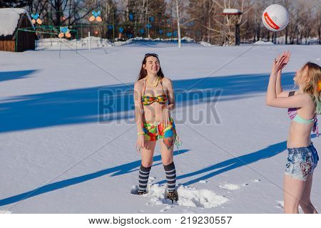 Novokuznetsk, Kemerovo region, Russia-23 Feb, 2017: White beaches of Siberia is an enterteiment activity where people playing beach games dressed in bikini in winter. Women playing volleyball on snow