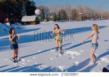 Novokuznetsk, Kemerovo region, Russia-23 Feb, 2017: White beaches of Siberia is an enterteiment activity where people playing beach games dressed in bikini in winter. Women playing volleyball on snow