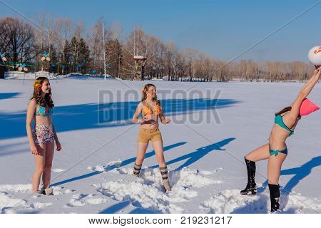 Novokuznetsk, Kemerovo region, Russia-23 Feb, 2017: White beaches of Siberia is an enterteiment activity where people playing beach games dressed in bikini in winter. Women playing volleyball on snow