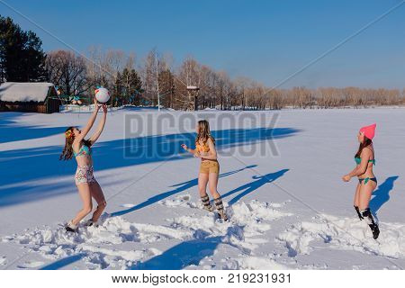 Novokuznetsk, Kemerovo region, Russia-23 Feb, 2017: White beaches of Siberia is an enterteiment activity where people playing beach games dressed in bikini in winter. Women playing volleyball on snow