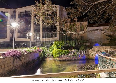 Bridge, oil mills and old platan in night with blue illuminations. Mlini. Croatia